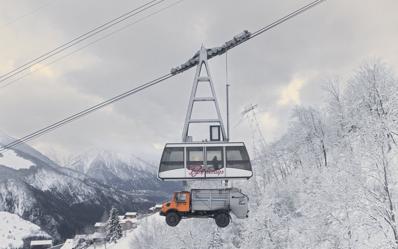 Der Müllwagen wird mit der Gondel ins Schweizer Skigebiet transportiert.