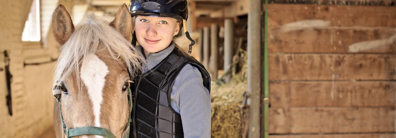 Helm und Sicher­heitsweste schützen beim Reiten.