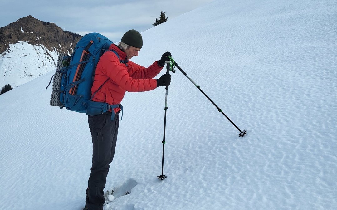 Gerry erklärt, wie man die Hangneigung mit Stöcken misst.
