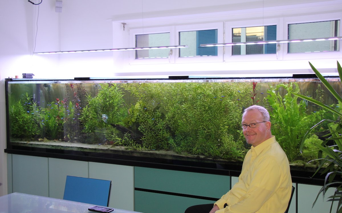 Jörg Blaser ist ein passionierter Aquarianer, der zahlreiche Becken unterhält. Hier sitzt er vor seinem Amazonas-Wohnzimmer-Aquarium. 