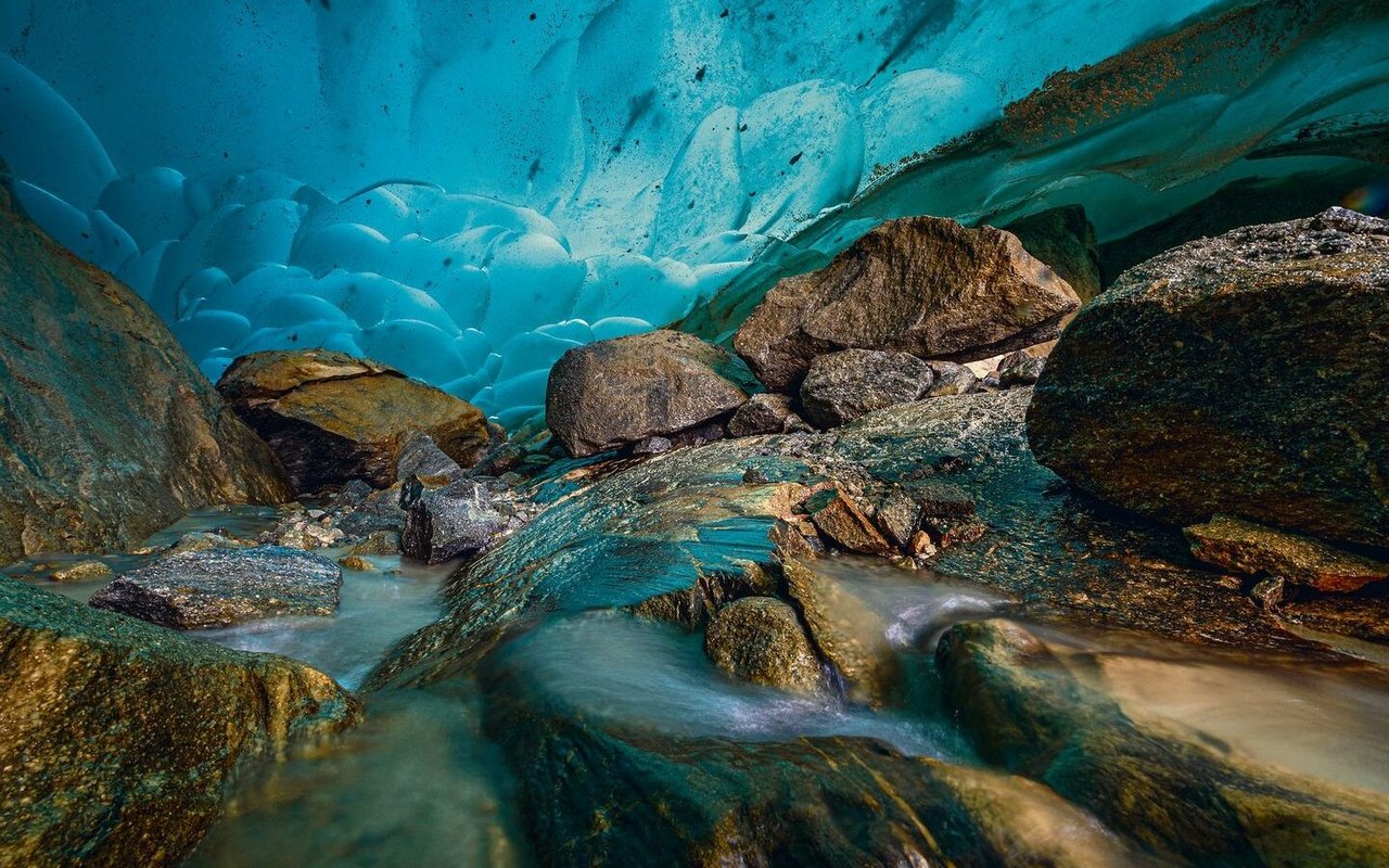 Eine tiefblaue Eishöhle am Gletscherrand.