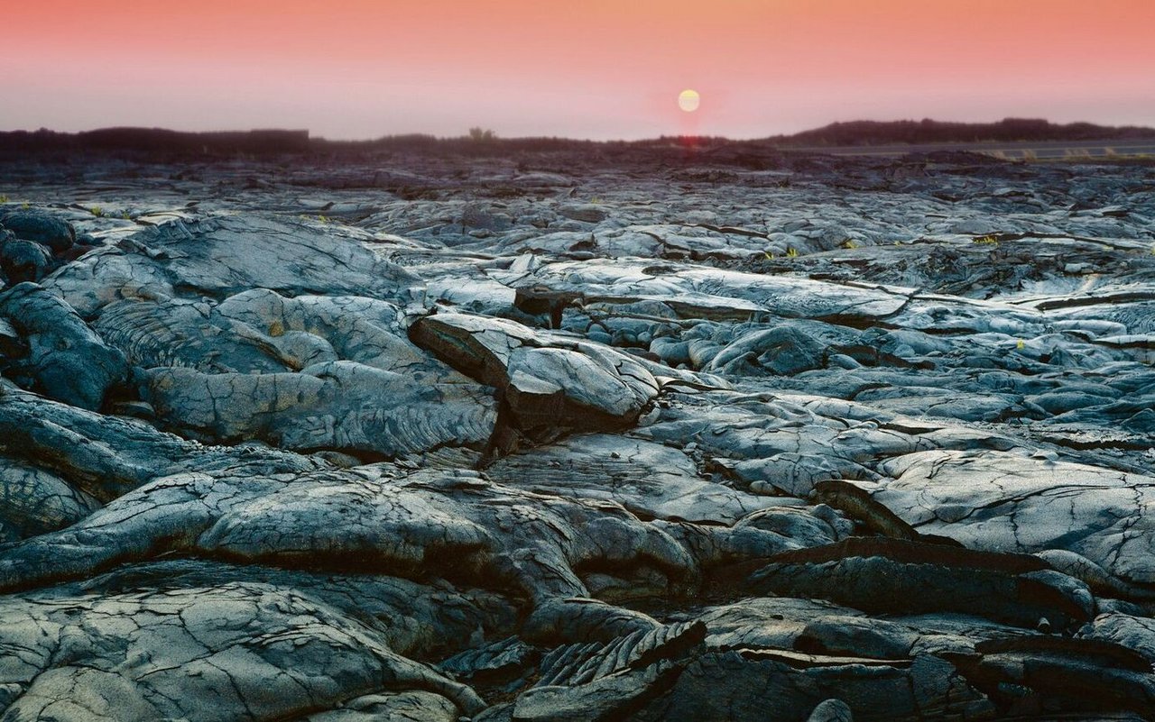 Die Sonne geht unter über der geschmolzenen, gekühlten Lava-Landschaft im Hawaii Volcanoes Nationalpark auf Big Island.