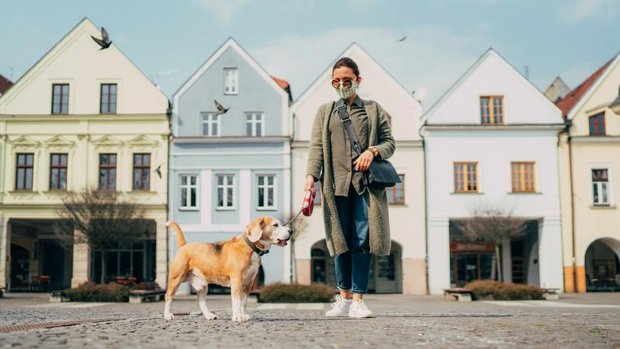 Frau mit Hund und Schutzmaske