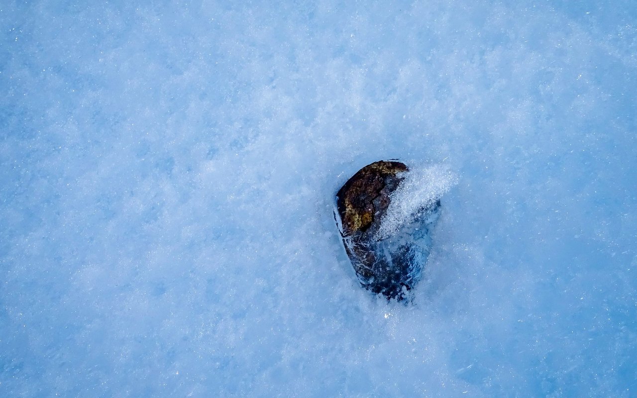 Die dunkle Farbe sorgt dafür, dass die Meteoriten erwärmen. Dies und höhere Temperaturen begünstigen das Einsinken ins Eis.