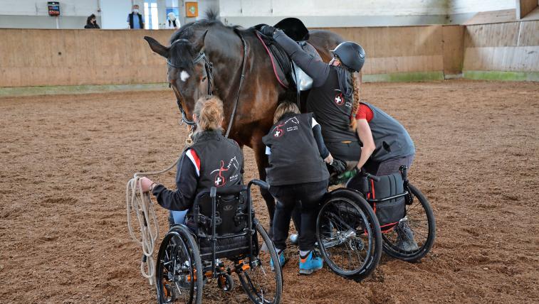 Teamwork ist alles: Während Anjadas Pferd hält, steigt Ramona mithilfe von Anjas Mutter Monika und Trainerin Lea auf.