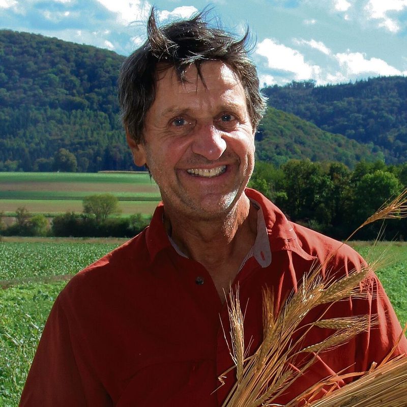 Dr. Markus Jenny mit Garben von Emmer und Einkorn im durch Biodiversitätsförderflächen aufgewerteten Gebiet östlich von Neunkirch (SH).