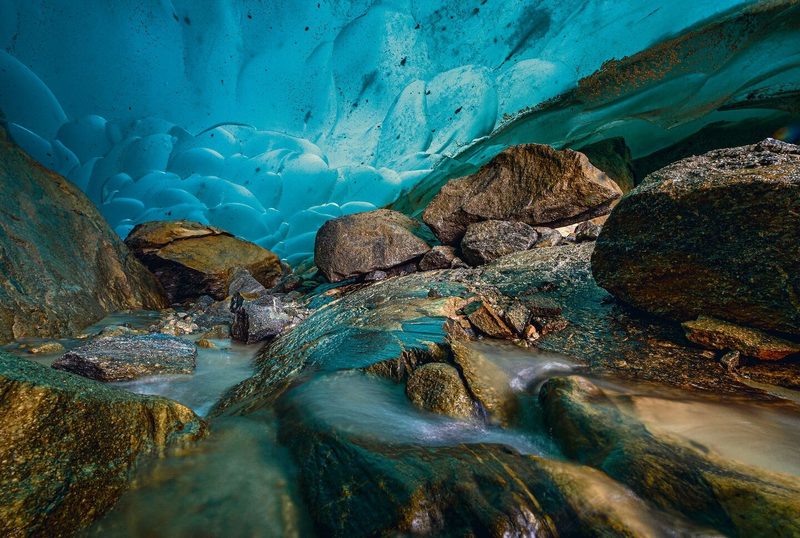 Eine tiefblaue Eishöhle am Gletscherrand.