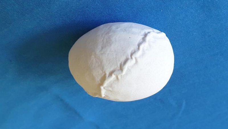 Deformiertes Ei auf blauem Untergrund